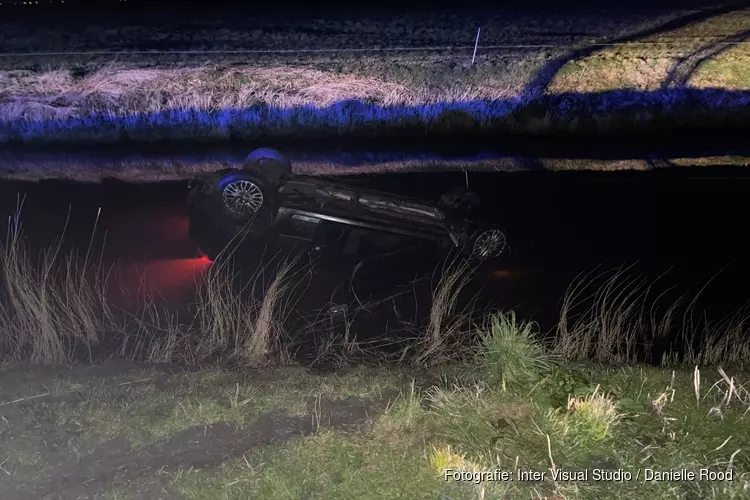 Auto op de kop in sloot in Oostwoud: twee mensen naar het ziekenhuis