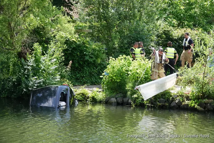 Auto te water in Hoorn, medewerkers gemeente schieten te hulp